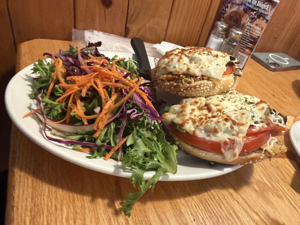 Bagel sandwich with melted cheese and a side salad at Bügel Fabrique de Bagels in Montcalm, Quebec City