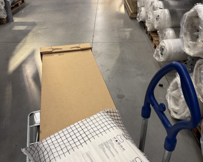 Shopping cart with boxed furniture and a pillow inside IKEA Quebec City